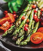 Cooked fresh tomatoes and asparagus a part of plant-based and whole food diet