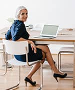 Woman sitting at desk at risk of developing deep vein thrombosis