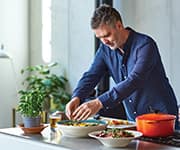 Man cooking with ingredients known for lycopene for better diet amounts