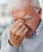 Senior man rubbing eyes due to discomfort of dry eye symptoms