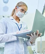 Lab technician holding laptop accessing the Autoimmune registry to find listed diseases