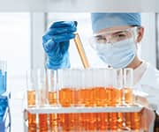 Researcher holding beaker of vitamin D for use in double-blind, placebo-controlled human study