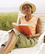 Woman reading on beach chair adhering to anti-inflammatory diet for dementia risk