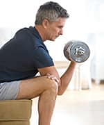 Mature man curling weight to maintain healthy muscle mass