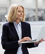 Businesswoman on laptop reading on stress and anxiety