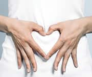 Woman making heart with fingers over vagina with healthy flora health