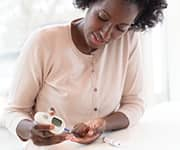 Woman taking blood glucose test for type II diabetes