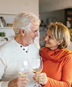 Husband and wife sharing glass of wine