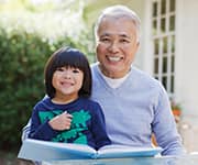 'Grandfather reading book with young grandchild