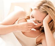 Woman sneezing into tissue from the common cold