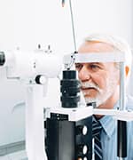 Older man sitting with topography machine for eye health