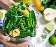 Woman making smoothie packed with vegetables and fruits for longevity benefits