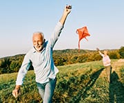 Over 60-year-old Husband running red kit away from wife in field