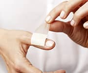 Woman winding band-aid around wound for wound-healing