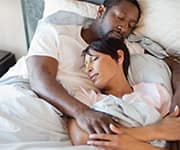 Couple sleeping in bed together with the help of melatonin