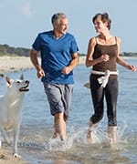 Couple with healthy gene expressions running on the beach